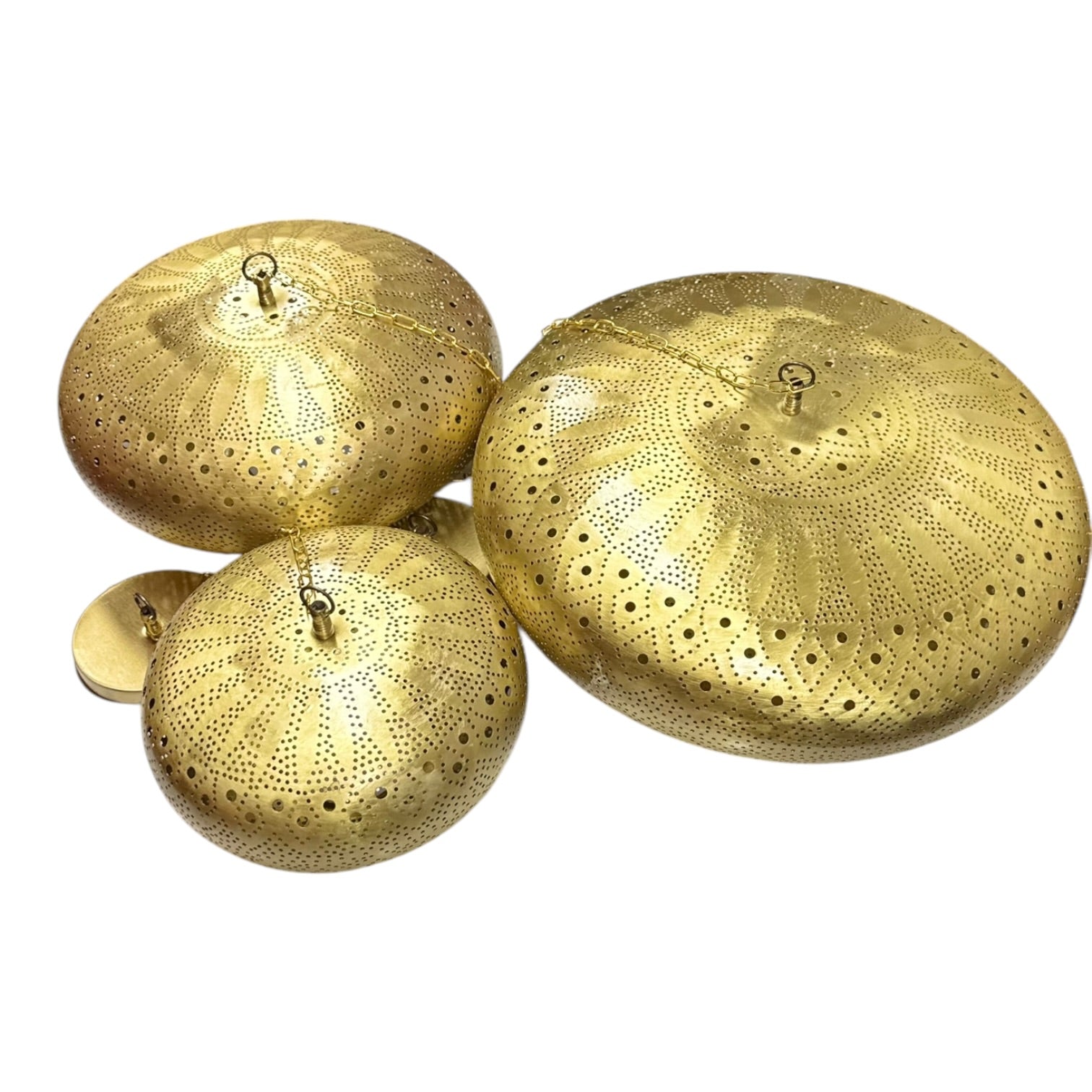 Three gold decorative lids with intricate patterns on a white background