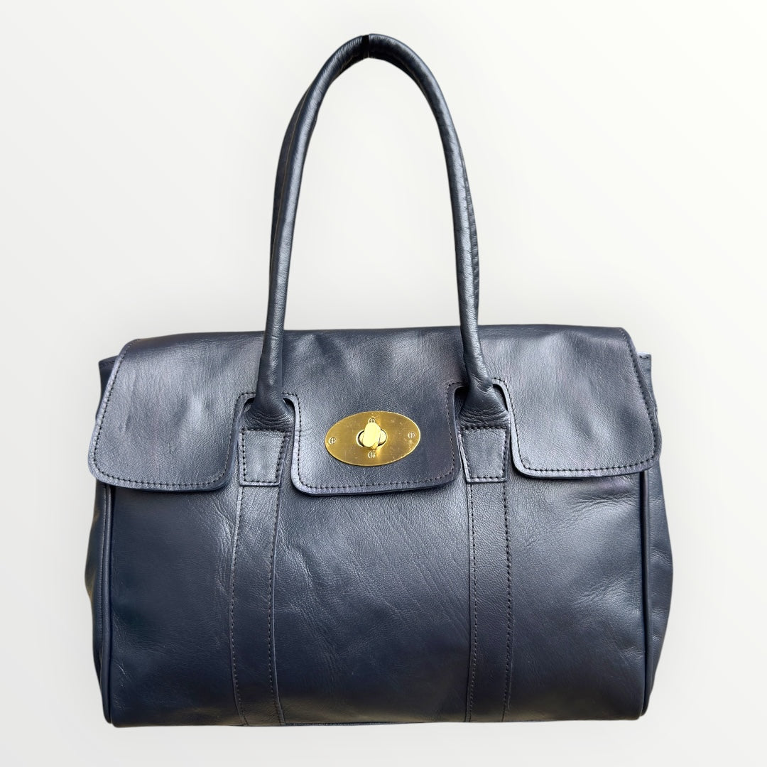 Black leather handbag with a gold clasp on a white background
