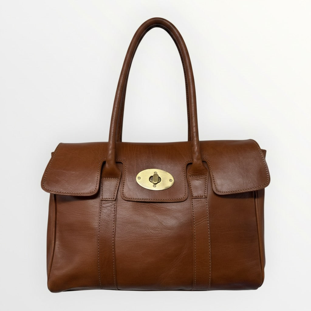 Brown leather handbag with a gold clasp on a white background