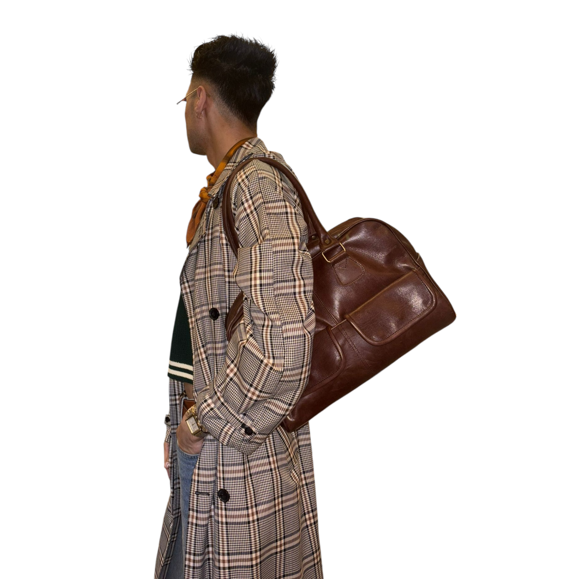 Person wearing a plaid coat with a brown leather bag over one shoulder on a white background