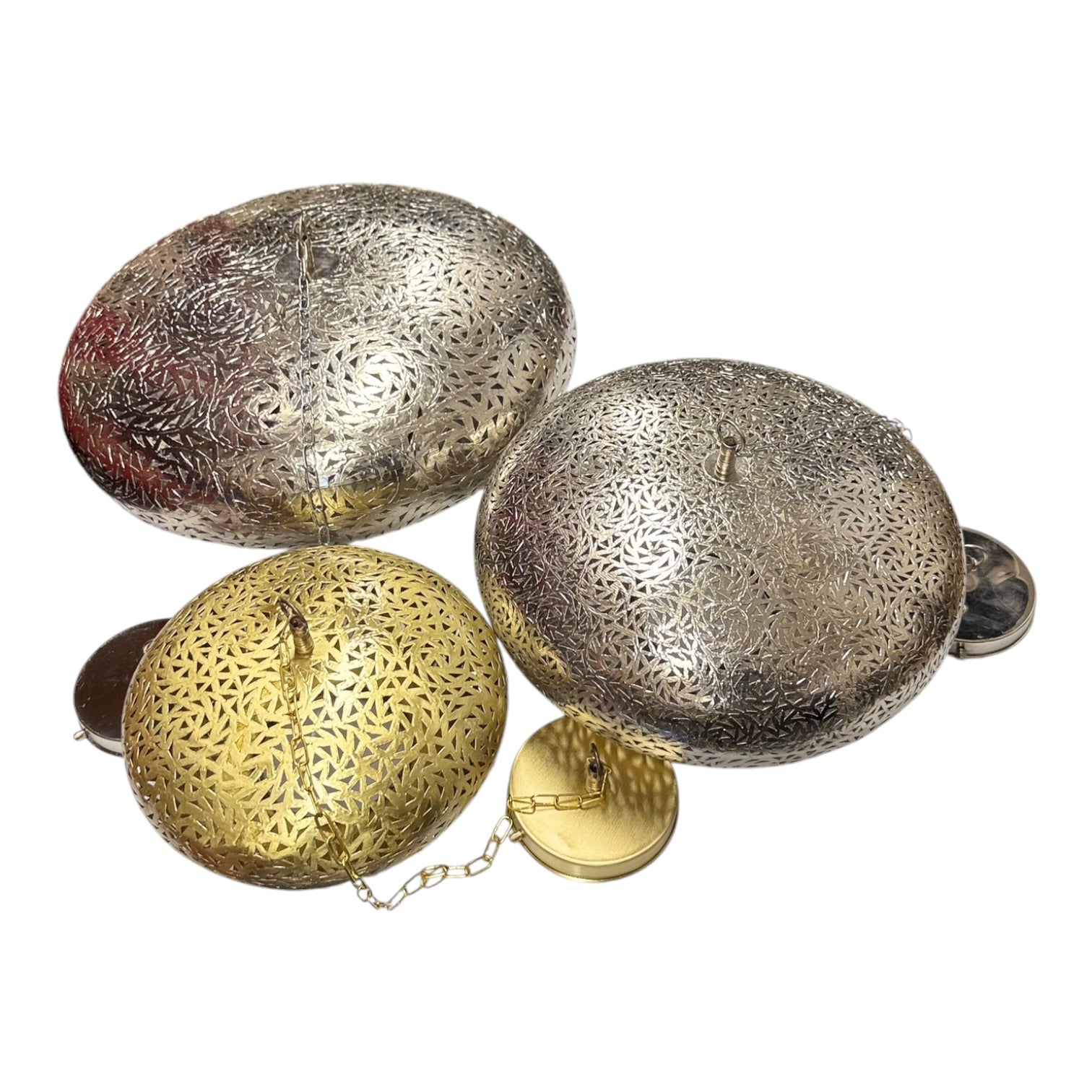 Three decorative metal objects with intricate patterns on a white background