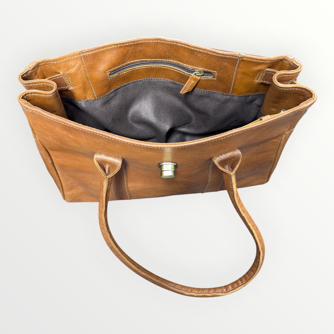 Brown leather handbag with a visible brand logo on a white background