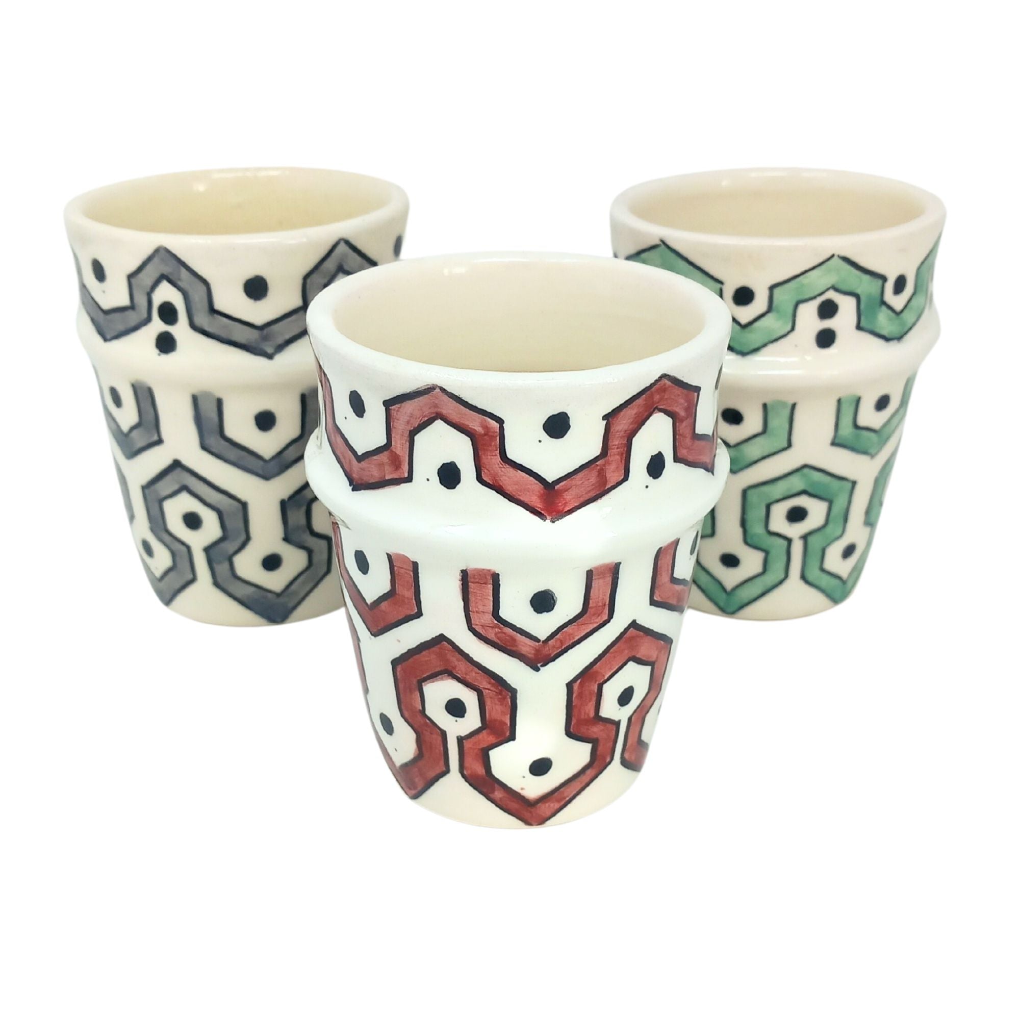 picture of three ceramic cups which have been fully handcrafted by artisans. In colours Burgundy red, mint Green and Grey.