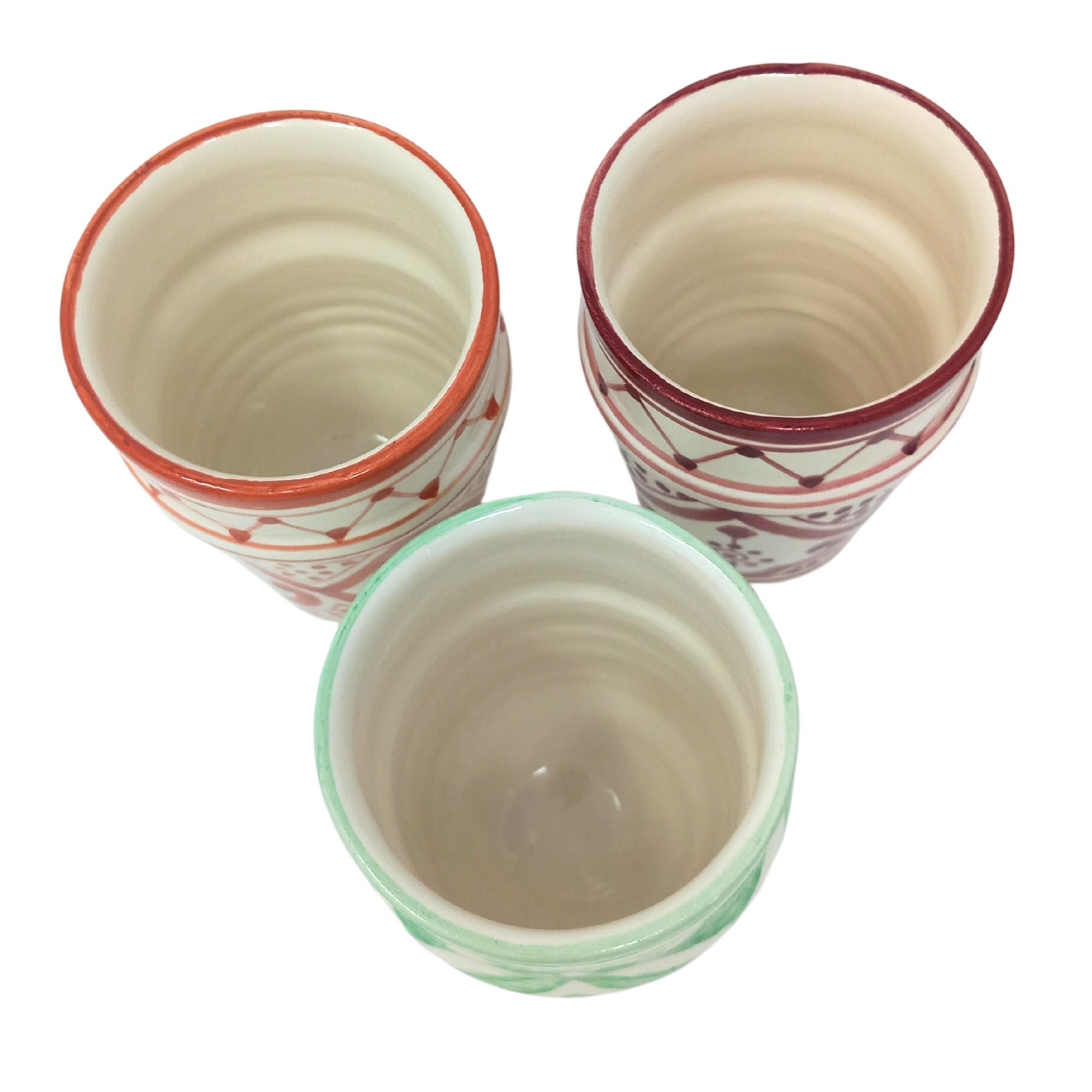 top view picture of handcrafted ceramic mugs in three colours: orange, mint green and burgundy red