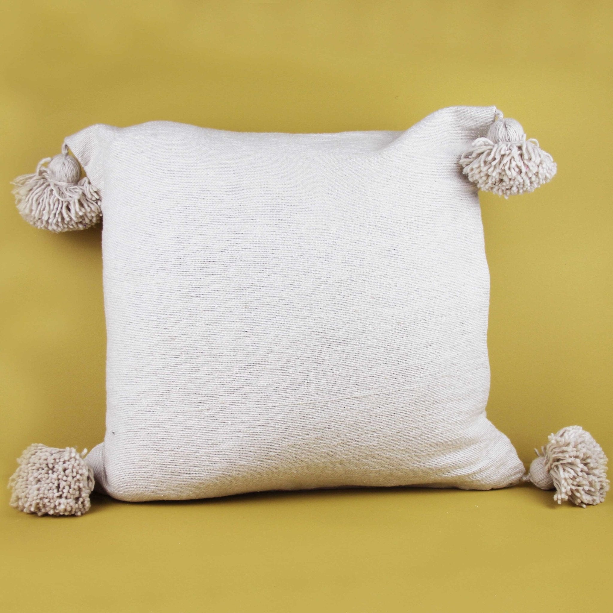 White pom pom store cushions